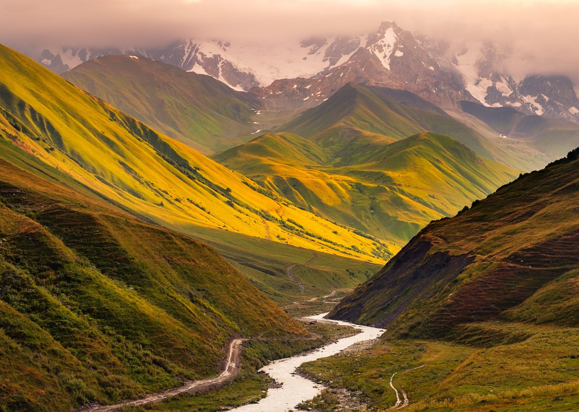 Beautiful sunrise with mountains, river and meadows in Ushguli, Georgia